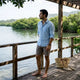 Man wearing cream linen shirt by ocean terrace
