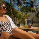 Woman in stylish poolside outfit lounging