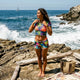 Woman in neon surfer-girl beach outfit on sand