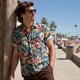 Man wearing Dan Flashes Hawaiian shirt on beach boardwalk