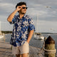 Man wearing Dan Flashes loose fit Hawaiian shirt on beach boardwalk