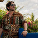 Man wearing Dan Flashes tropical shirt on resort patio
