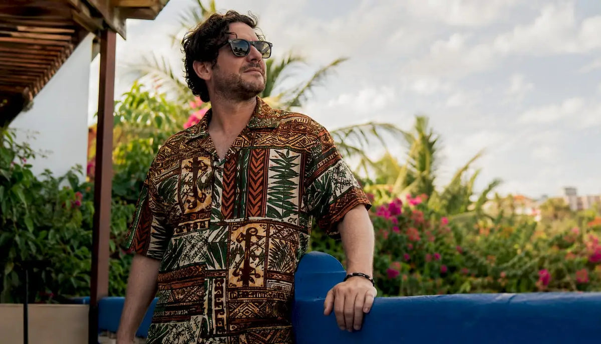Man wearing Dan Flashes tropical shirt on resort patio