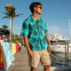Man wearing Dan Flashes yellow floral shirt on beach boardwalk