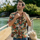 Man adjusting collar of Dan Flashes canoe shirt on boardwalk