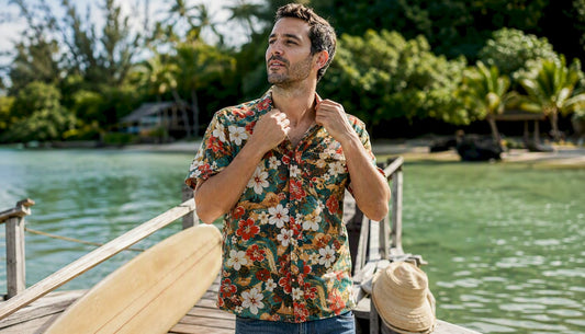 Man adjusting collar of Dan Flashes canoe shirt on boardwalk
