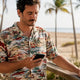 Man reading return policy on phone outdoors