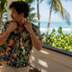 Man adjusting Hawaiian shirt on resort patio