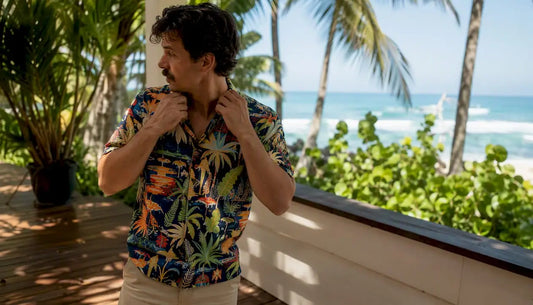Man adjusting Hawaiian shirt on resort patio