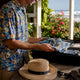 Man folding colorful Hawaiian shirt while packing