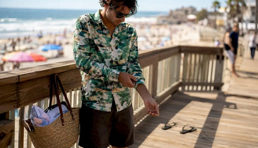 Man adjusting sleeve of tropical print shirt