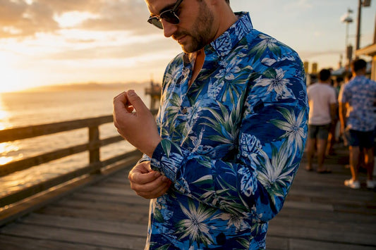Man adjusting Dan Flashes shirt cuff on beach