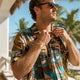 Man adjusting collar in hemp shirt on beach
