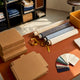 Fabric rolls, swatches, measuring tape and boxes arranged on a table