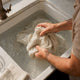 Adult man's hands rinsing linen fabric