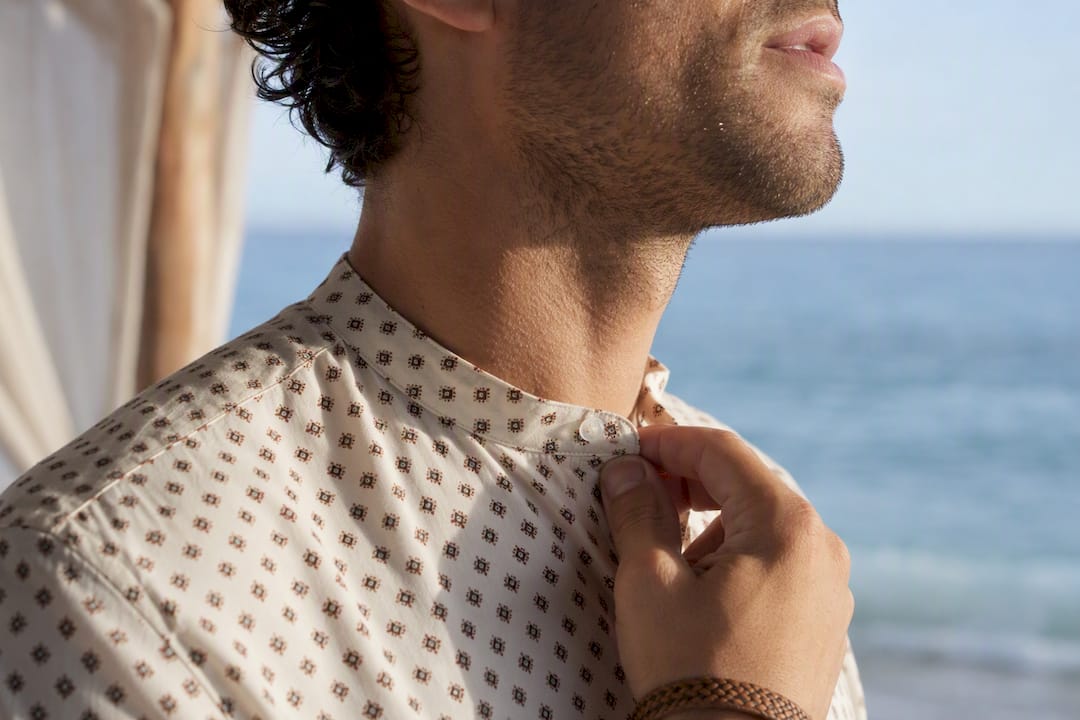 Adult man adjusting band collar by beach