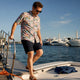 Man in bold shirt boarding boat safely