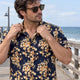 Man checking the fit of a floral camp shirt