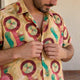 Adult man fastening a patterned shirt’s buttons