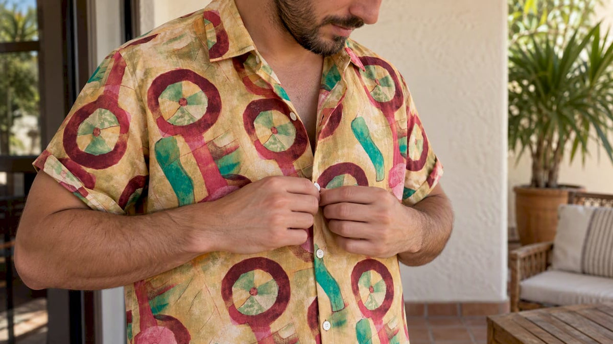 Adult man fastening a patterned shirt’s buttons