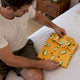 Man folding a patterned shirt for return