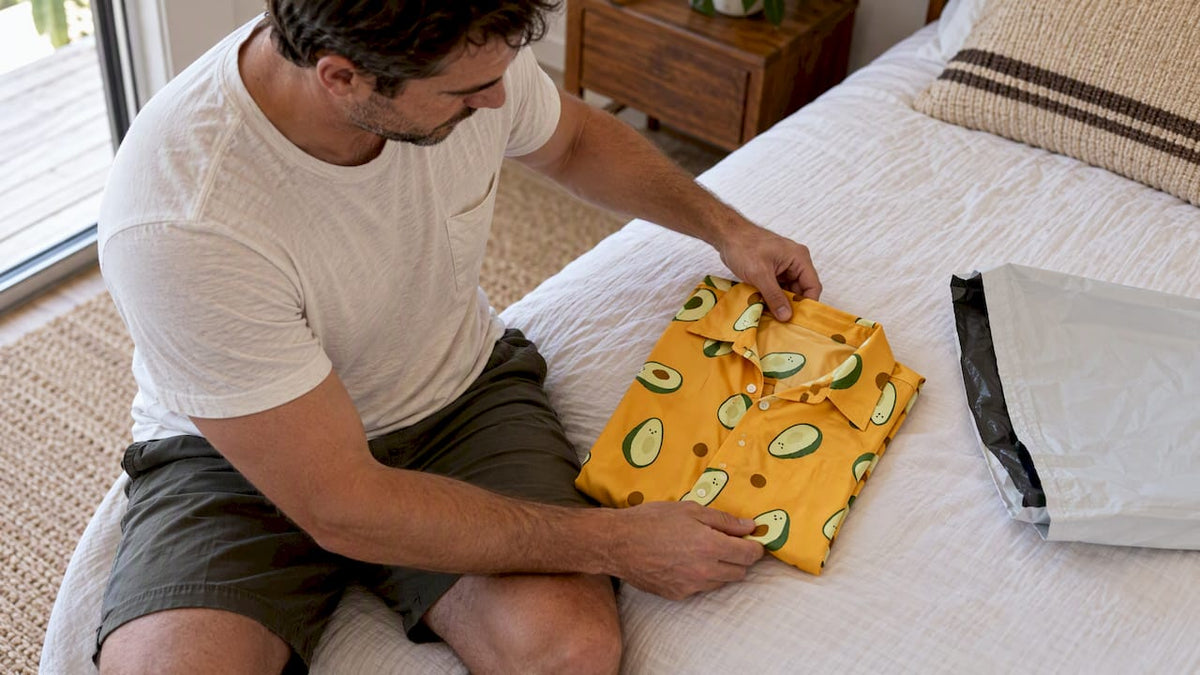 Man folding a patterned shirt for return
