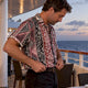 Man tucking patterned shirt before dinner