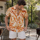 Man checking hem of patterned Hawaiian shirt