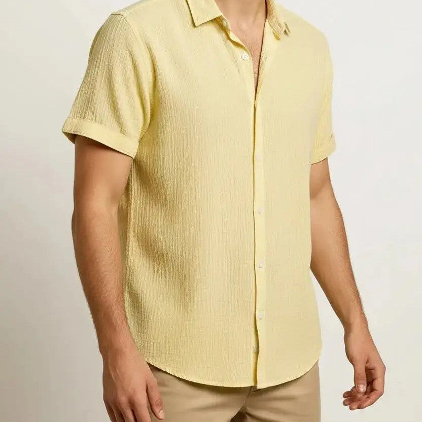 Man wearing a pale yellow short-sleeve collared shirt