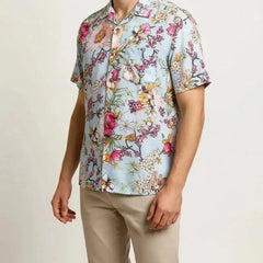 Man wearing a light-colored shirt with multicolor floral motifs