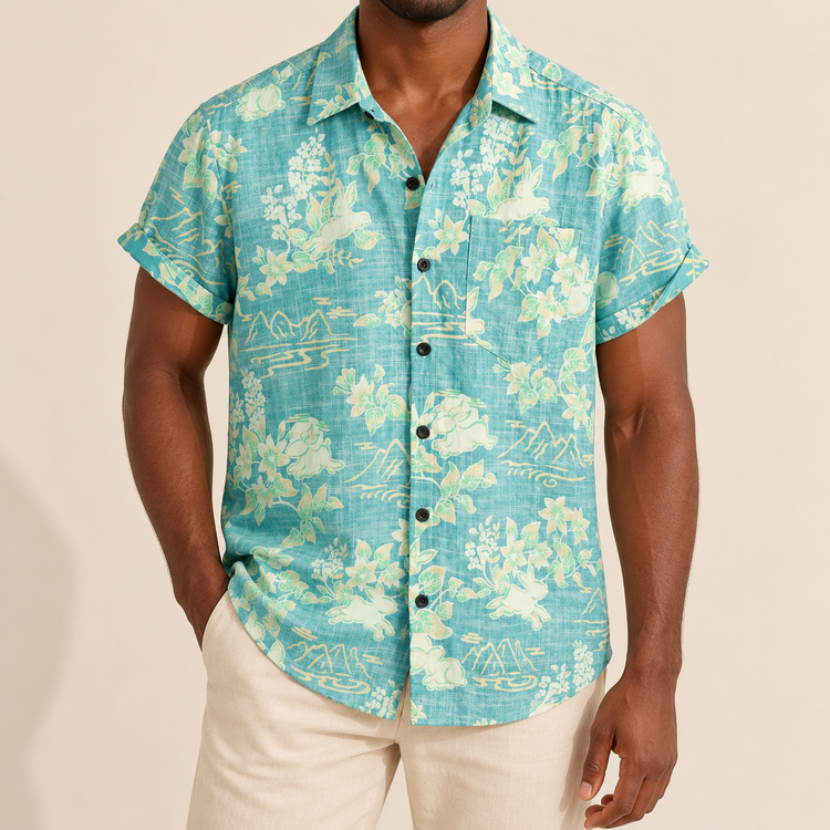 Model wearing a aqua short-sleeve shirt with cream rabbit and floral motifs