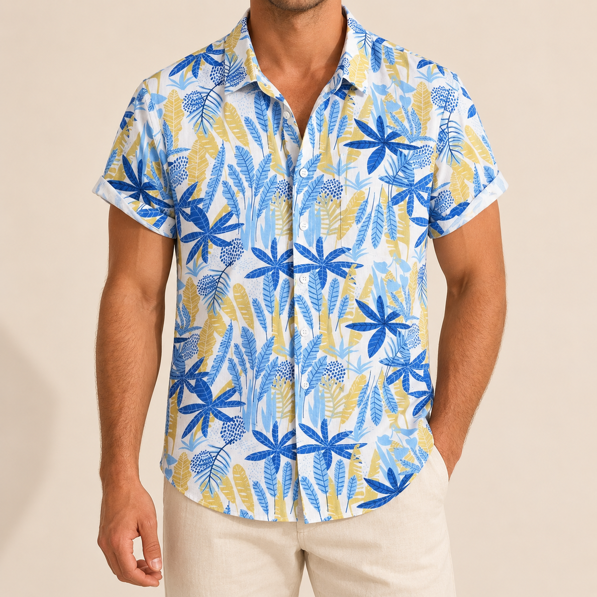 Model wearing a white Hawaiian shirt with blue, turquoise and pale gold leaves
