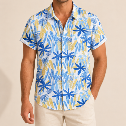 Model wearing a white Hawaiian shirt with blue, turquoise and pale gold leaves