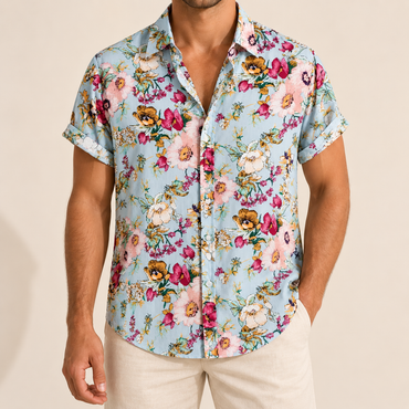 Model wearing a pale blue short-sleeve button-up shirt with colorful garden flowers