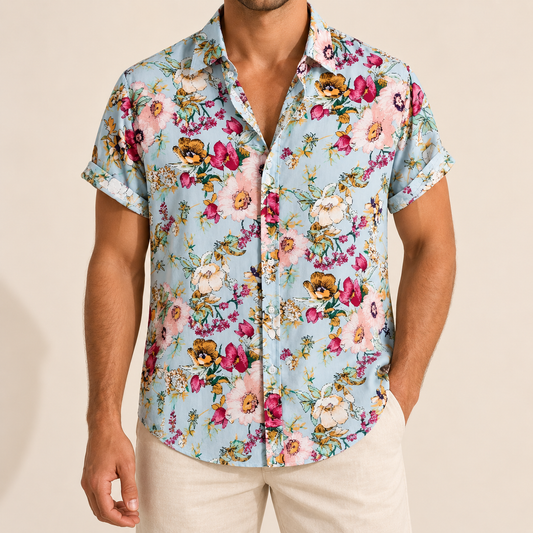 Model wearing a pale blue short-sleeve button-up shirt with colorful garden flowers