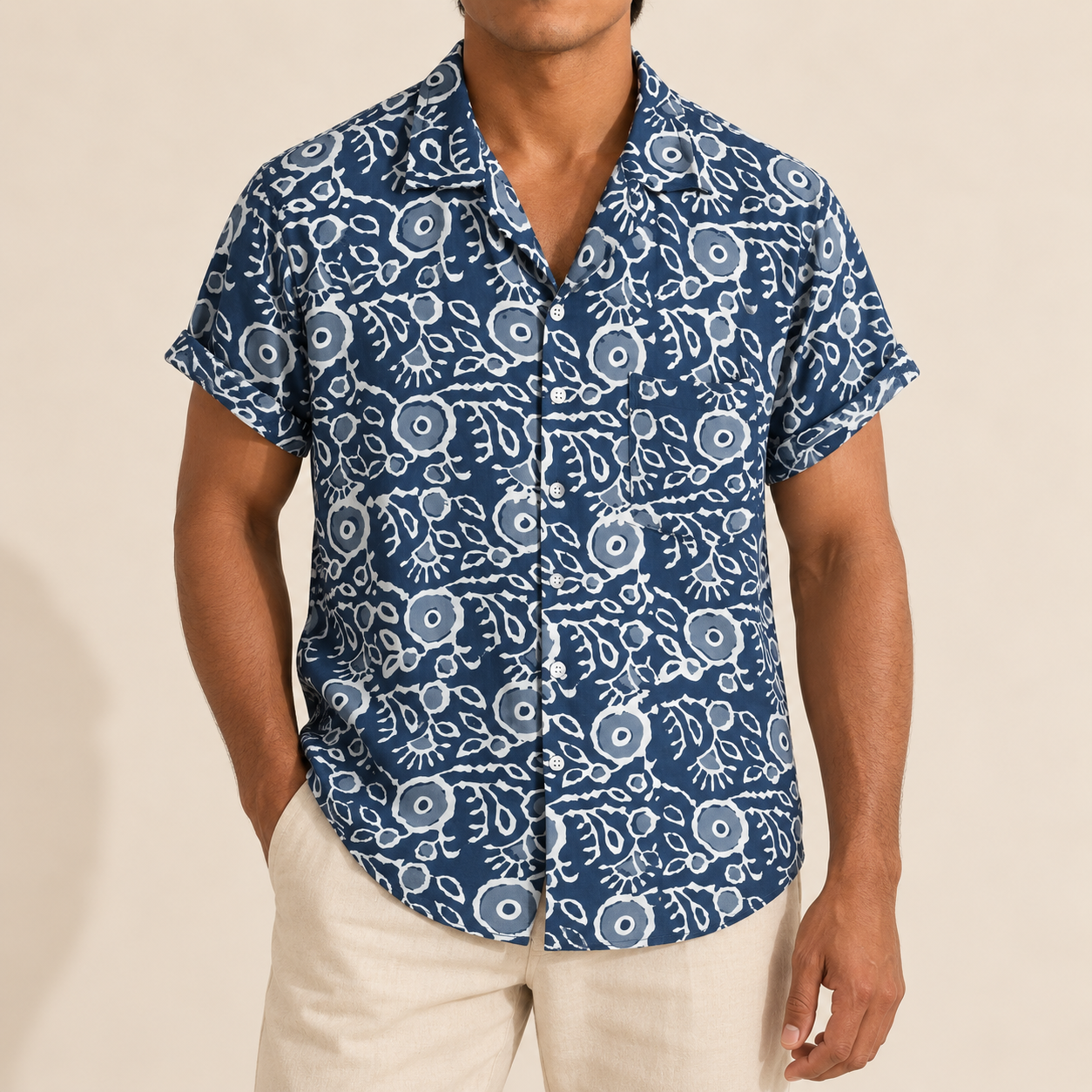 Model wearing a navy short-sleeve shirt with white outlined botanical motifs