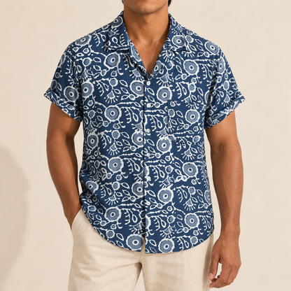 Model wearing a navy short-sleeve shirt with white outlined botanical motifs