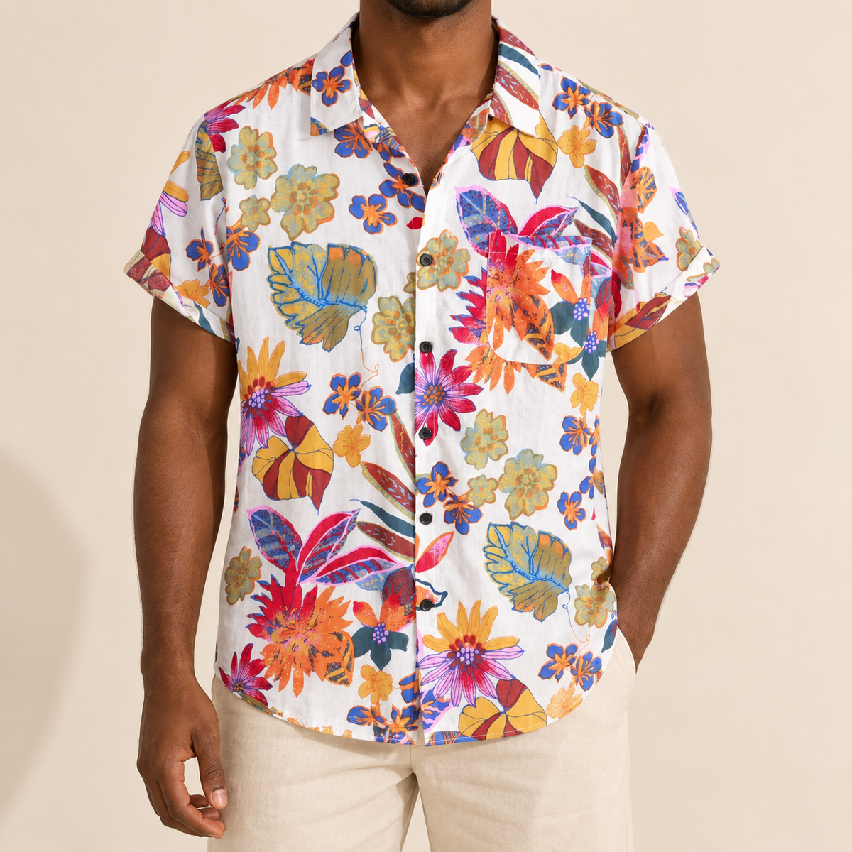 Model wearing light short-sleeve vacation shirt with large colorful botanical shapes