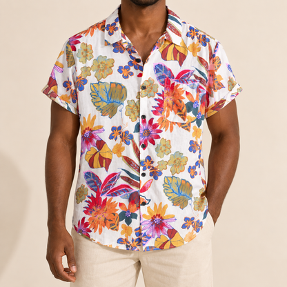 Model wearing light short-sleeve vacation shirt with large colorful botanical shapes
