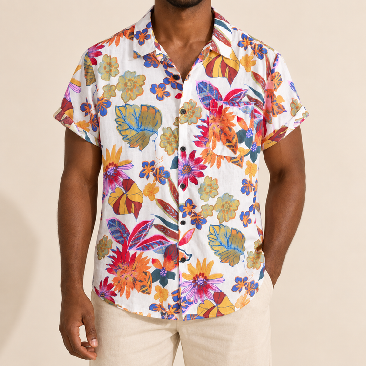Model wearing light short-sleeve vacation shirt with large colorful botanical shapes