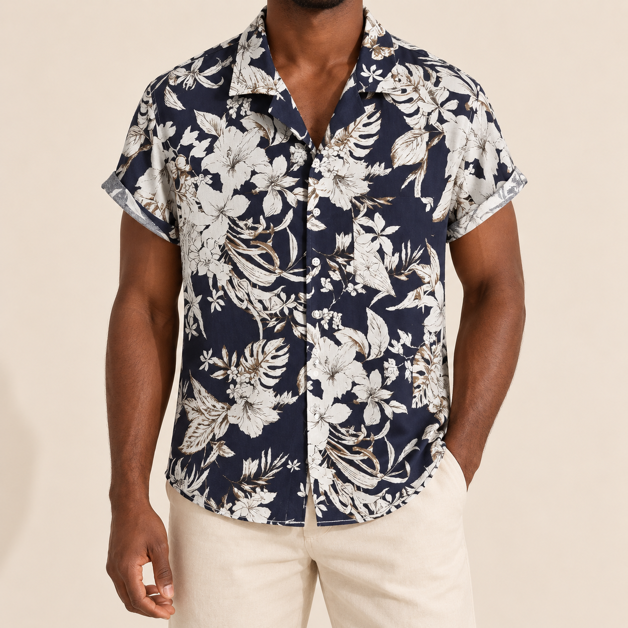 Model wearing a navy short-sleeve shirt with cream botanical flowers and leaves