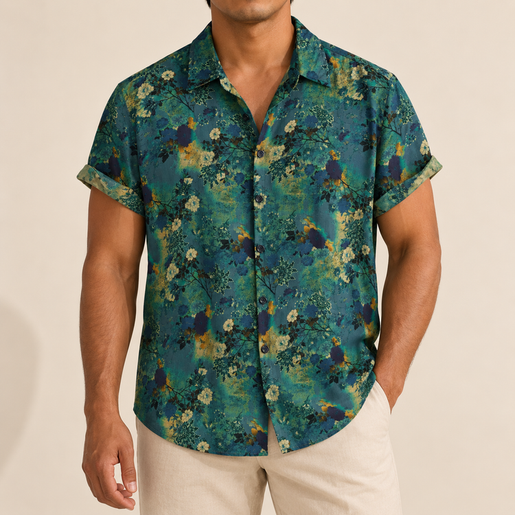 Model wearing dark green short-sleeve shirt with small muted flowers and leaf details