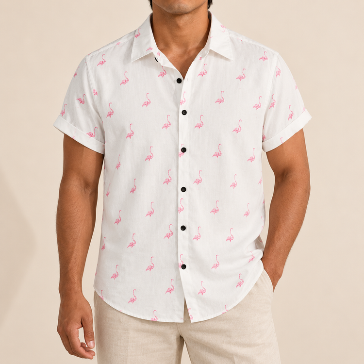 Model wearing a white short-sleeve shirt with small pink flamingos