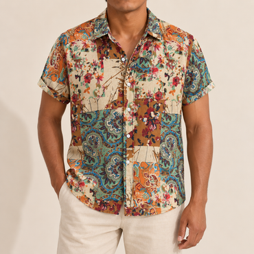 Model wearing a short-sleeve shirt with green, orange and cream floral paisley panels
