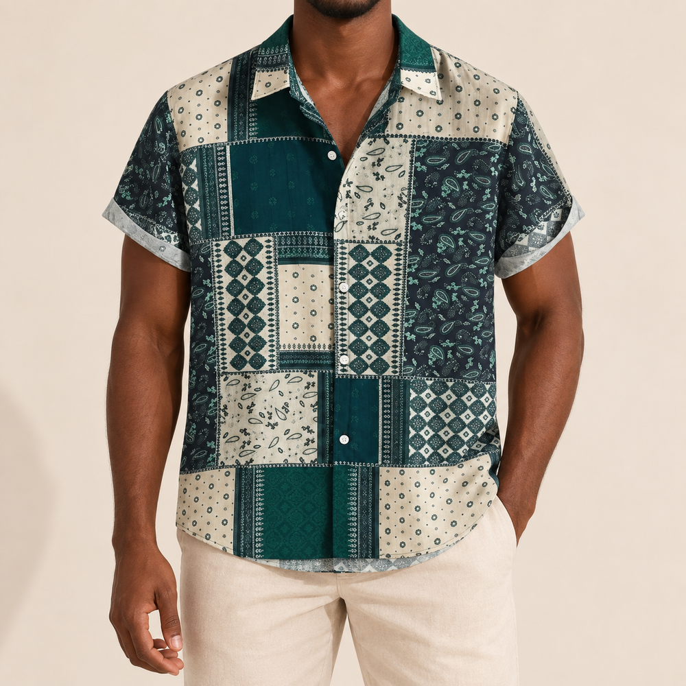 Model wearing green and pale short-sleeve shirt with geometric and ornamental patchwork-style panels