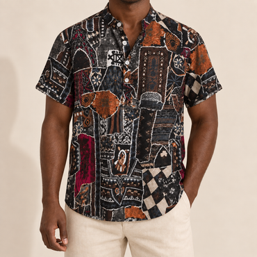 Model wearing a dark band-collar shirt with abstract shapes and rust accents
