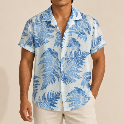 Model wearing a white short-sleeve shirt with blue fern leaves