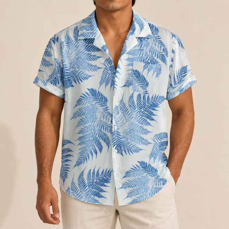 Model wearing a white short-sleeve shirt with blue fern leaves