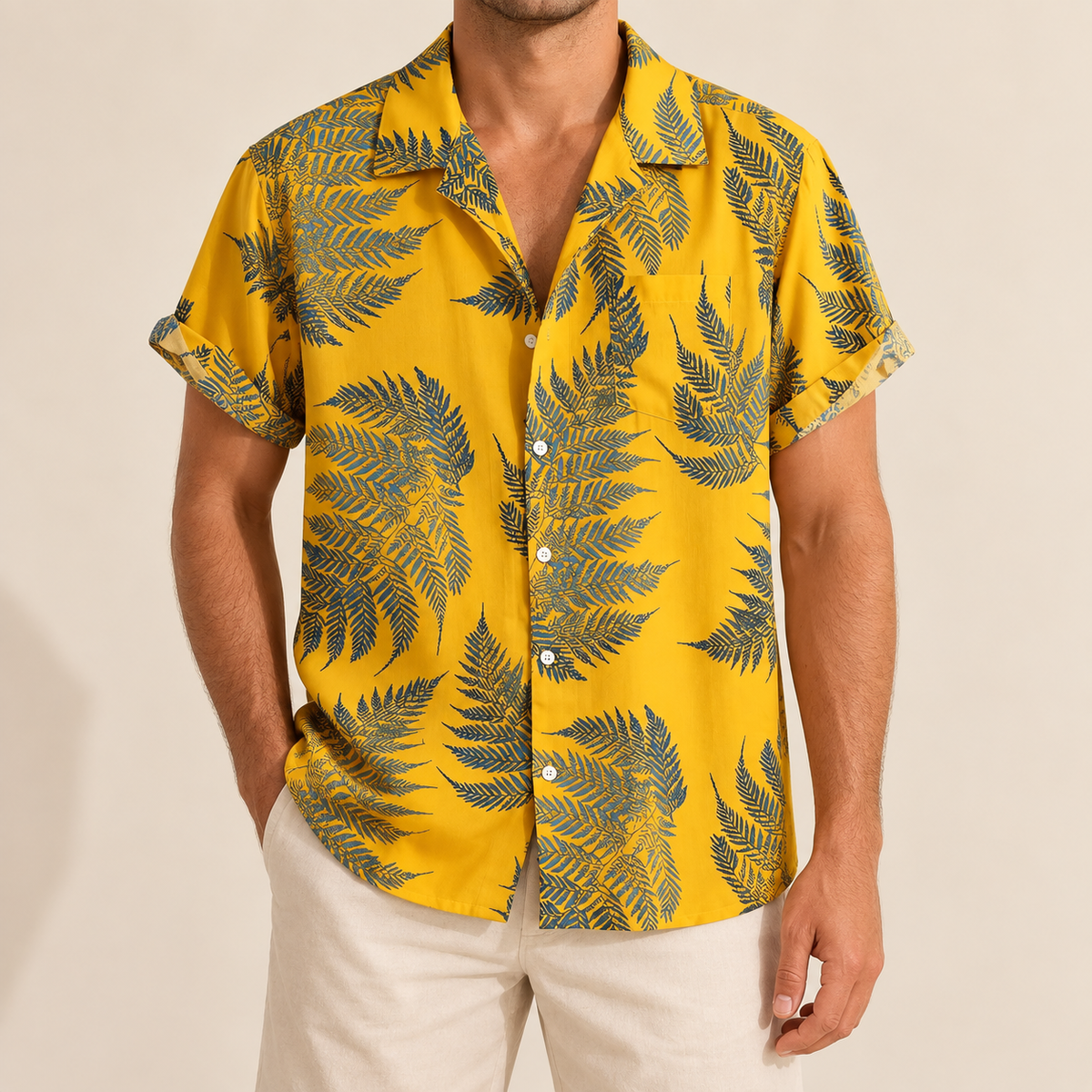 Model wearing yellow Hawaiian shirt with dark palm and leafy silhouettes