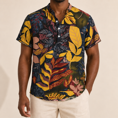 Model wearing a dark short-sleeve shirt with yellow, burgundy and pink leaves